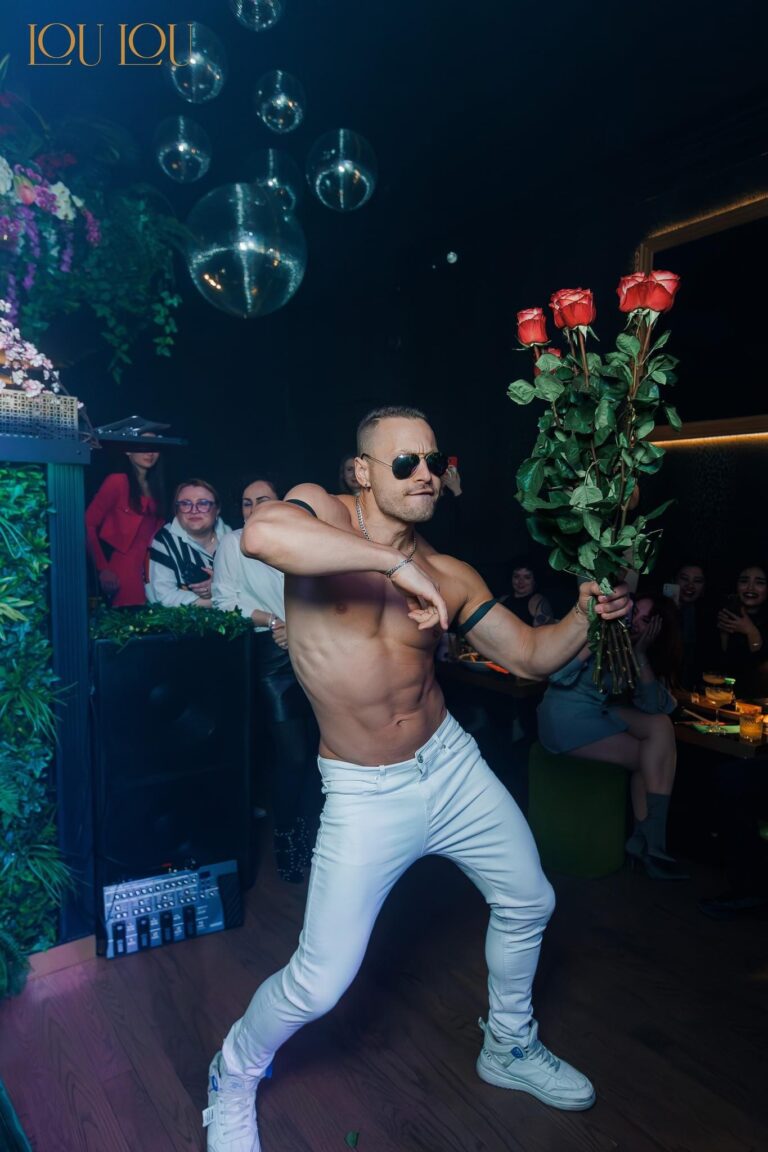Group of women enjoying a bachelorette party with a male stripper performance