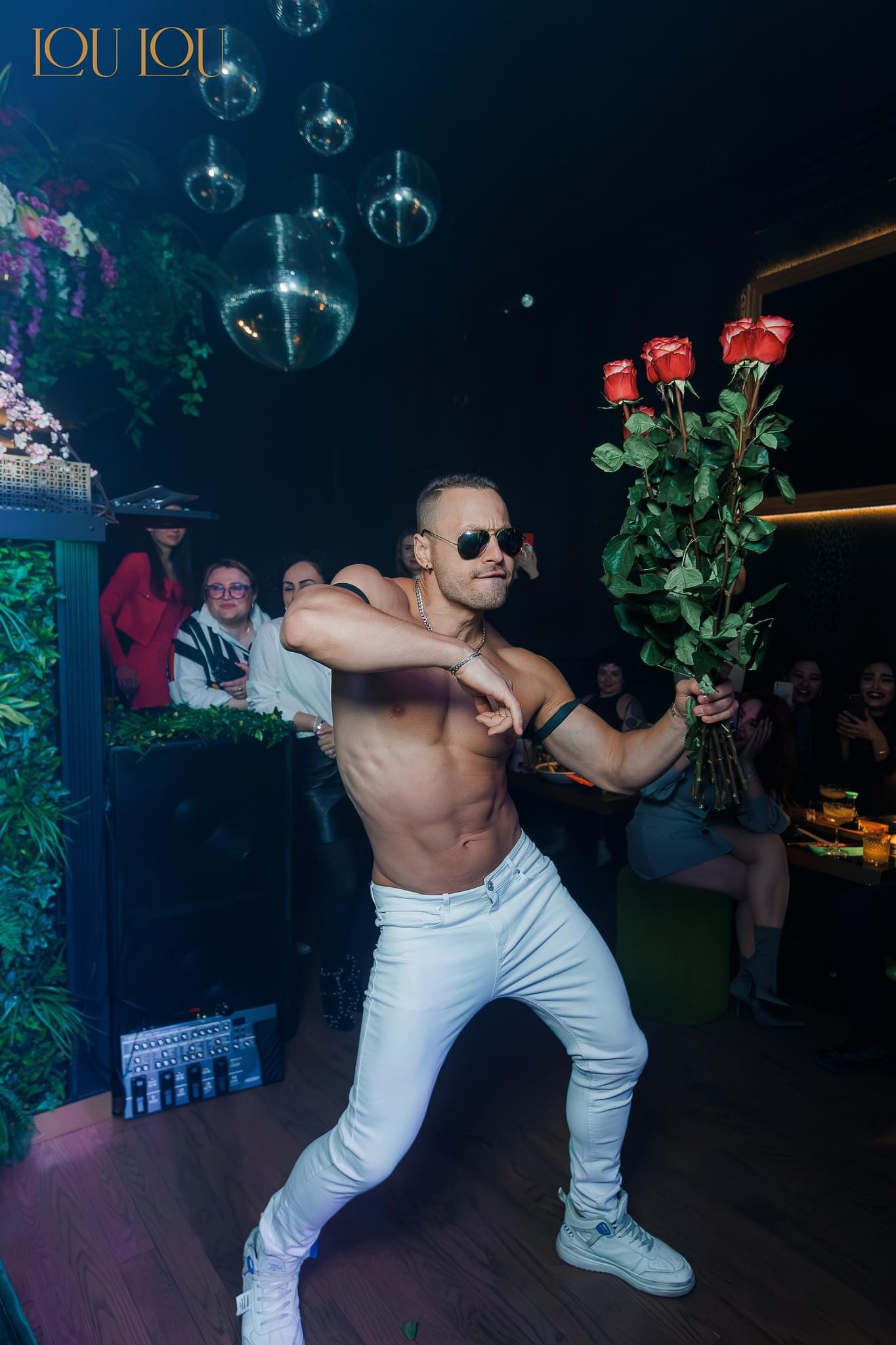 Group of women enjoying a bachelorette party with a male stripper performance